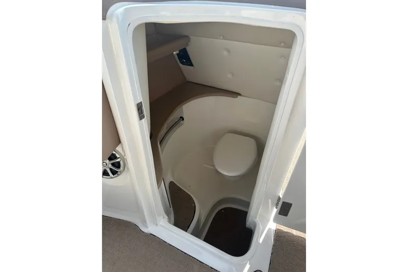 Slide: The Image of 2010 Cobalt 302 boat interior showing compact marine toilet compartment. - 13