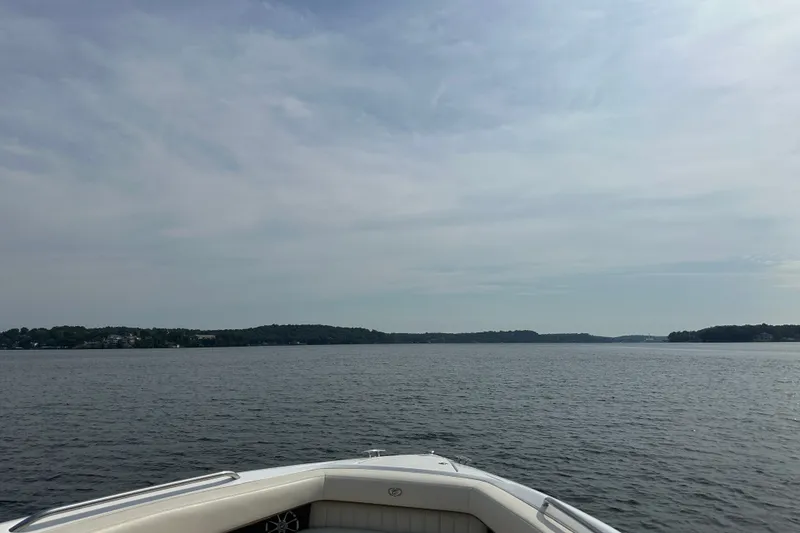 Slide: The Image of Bow of 2010 Cobalt 302 boat on a calm lake under a cloudy sky. - 10