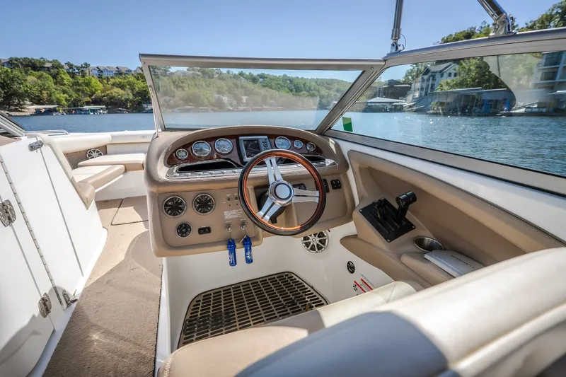 Slide: The Image of Interior view of a 2010 Cobalt 302 boat cockpit with steering wheel and controls. - 40
