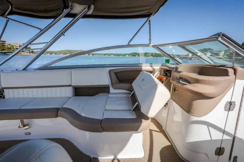Slide: The Image of Interior of a 2010 Cobalt 302 boat with beige and white seating, overlooking a serene lake. - 27