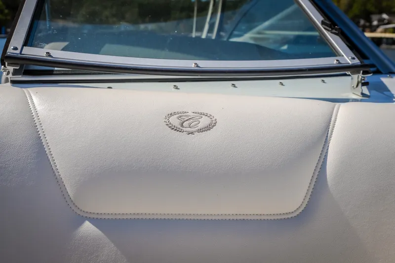 Slide: The Image of 2010 Cobalt 302 boat dashboard with embossed logo, featuring sleek white upholstery. - 21