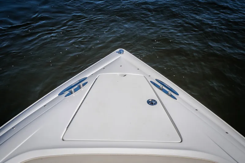 Slide: The Image of Bow of a 2010 Cobalt 302 boat on water, featuring sleek design and cleats. - 19