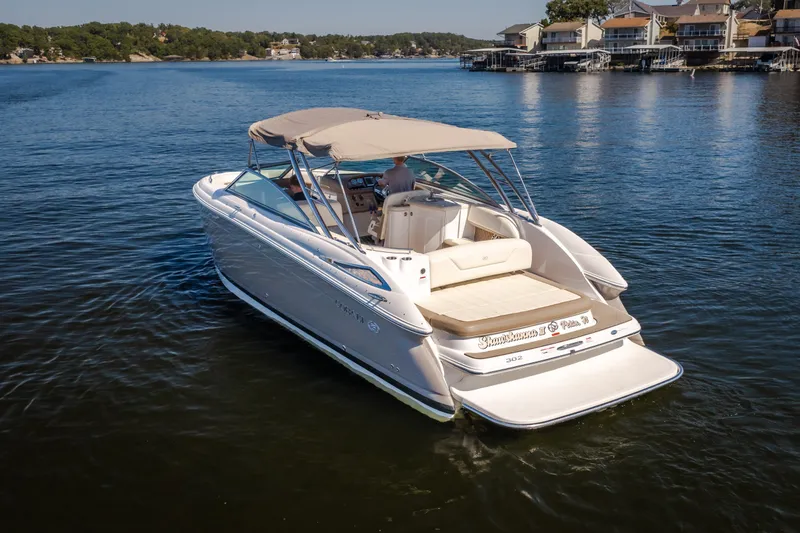 Slide: The Image of 2010 Cobalt 302 boat cruising on a serene lake with waterfront homes in the background. - 10