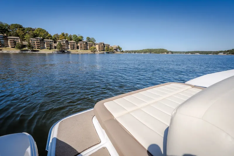 Slide: The Image of 2010 Cobalt 302 boat on a serene lake with waterfront buildings in the background. - 34