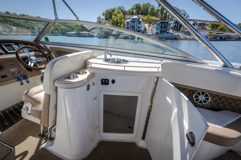 Slide: The Image of Interior of a 2010 Cobalt 302 boat with steering wheel and sink. - 31