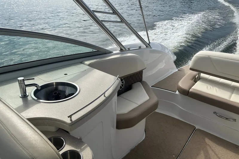 Slide: The Image of 2010 Cobalt 302 boat interior with sink and seating, cruising on water. - 5