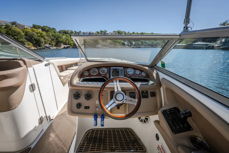 Slide: The Image of Cockpit view of a 2010 Cobalt 302 boat with steering wheel and dashboard controls. - 43