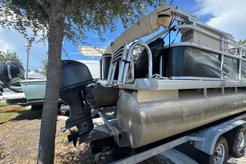 Slide: The Image of 2017 Godfrey Sweetwater Sunrise 22 pontoon boat on trailer, parked under a tree. - 20