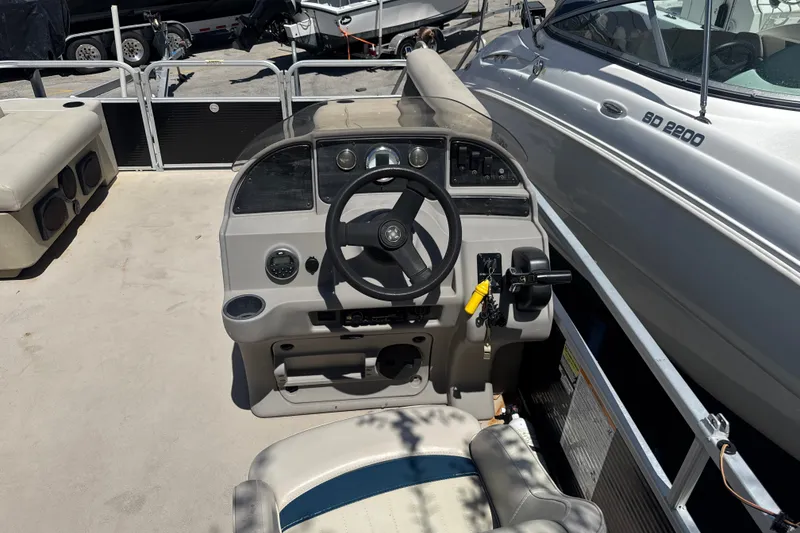 Slide: The Image of 2017 Godfrey Sweetwater Sunrise 22 boat cockpit with steering wheel and controls. - 11