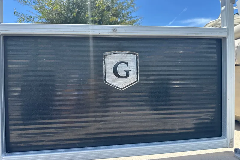 Slide: The Image of 2017 Godfrey Sweetwater Sunrise 22 boat emblem with "G" logo on a dark panel. - 21