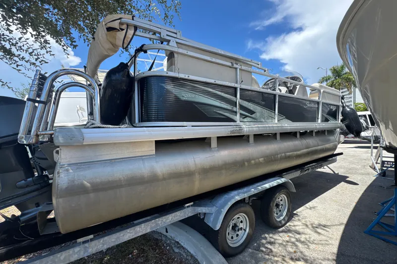 The Image of 2017 Godfrey Sweetwater Sunrise 22 pontoon boat on trailer under blue sky. - 0