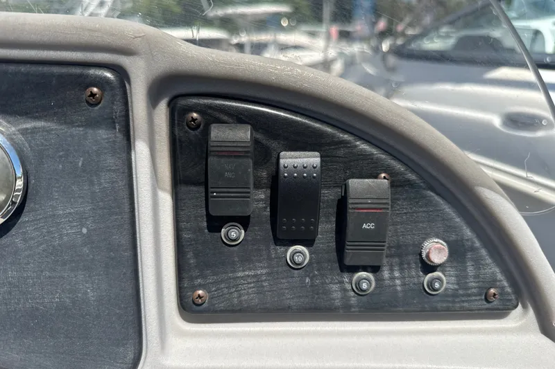 Slide: The Image of Control panel of a 2017 Godfrey Sweetwater Sunrise 22 boat with switches and knobs. - 14