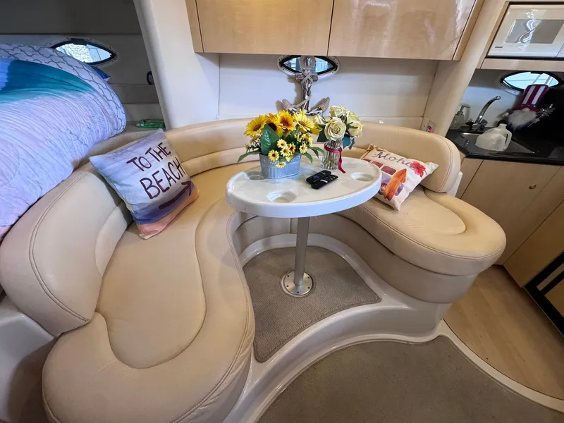 Slide: The Image of Interior of a 2001 Maxum 3500 SCR with a curved leather sofa and small table. - 13