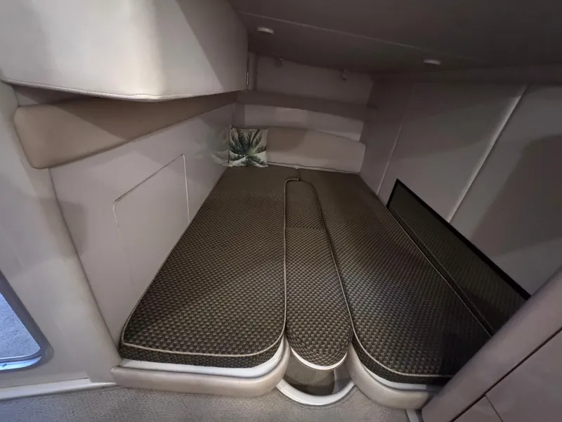 Slide: The Image of The cabin of the 2001 Maxum 3500 SCR features a cushioned sleeping area with a pillow. - 16