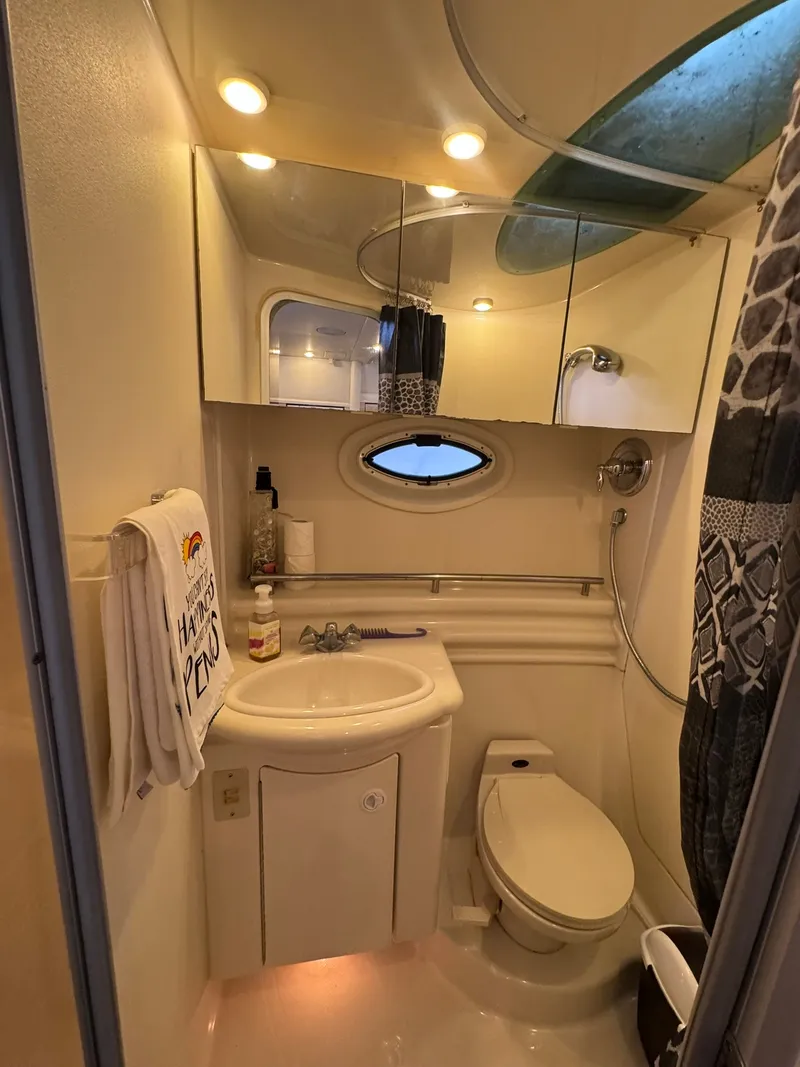 Slide: The Image of The image shows a boat bathroom with a sink, toilet, and shower. There's a mirror and small window. - 17