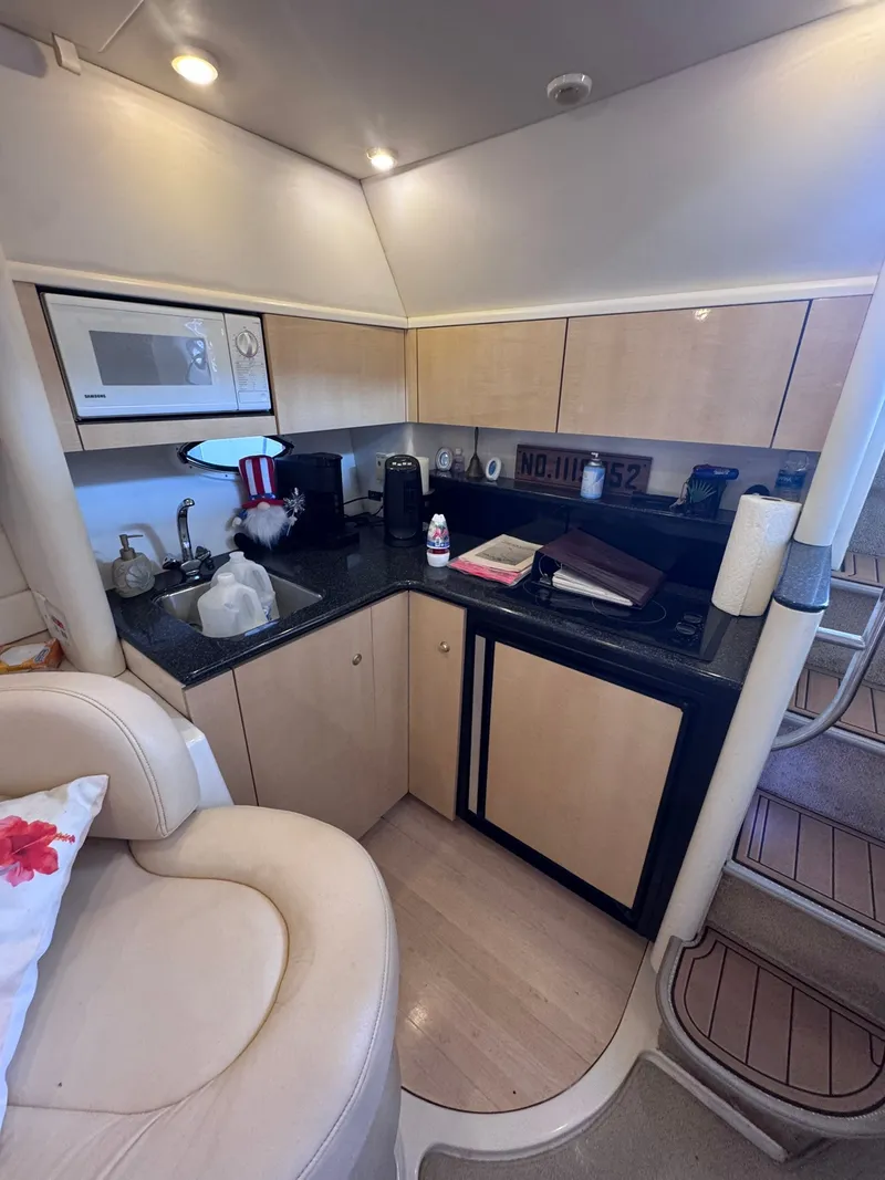 Slide: The Image of The galley of a 2001 Maxum 3500 SCR with a microwave, sink, and refrigerator. - 14