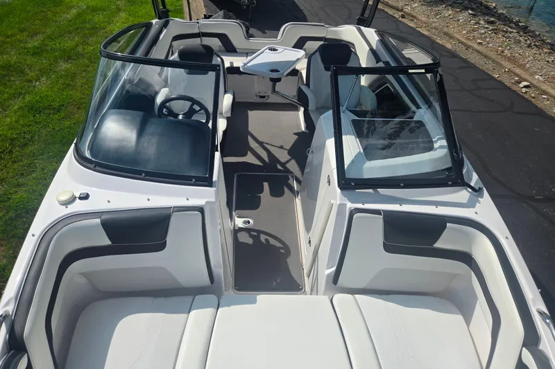 Slide: The Image of 2016 Yamaha Boats AR240 interior with seating and steering wheel, docked near water. - 21