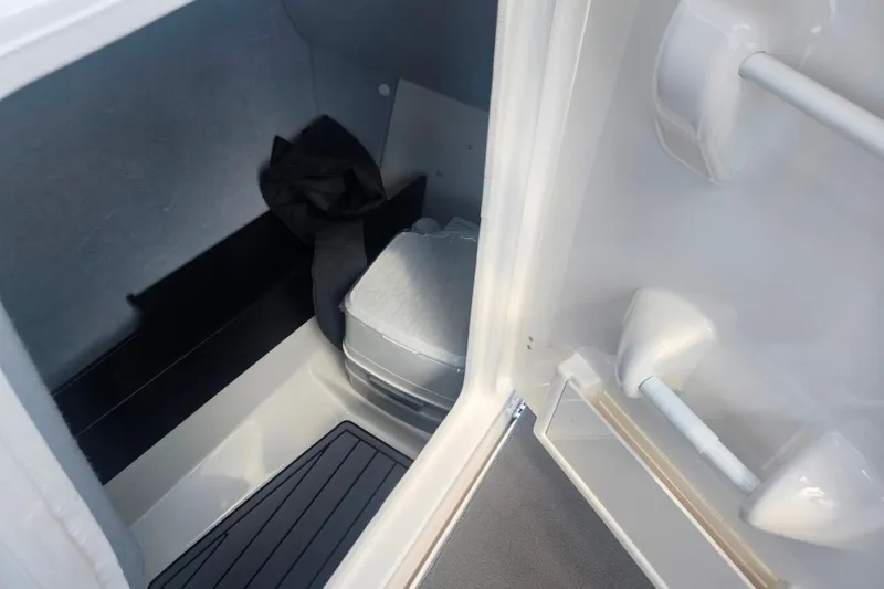 Slide: The Image of 2016 Yamaha AR240 boat interior with compact toilet and storage space. - 16