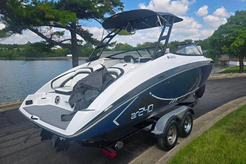 Slide: The Image of 2016 Yamaha AR240 boat on trailer by a scenic lake. - 1