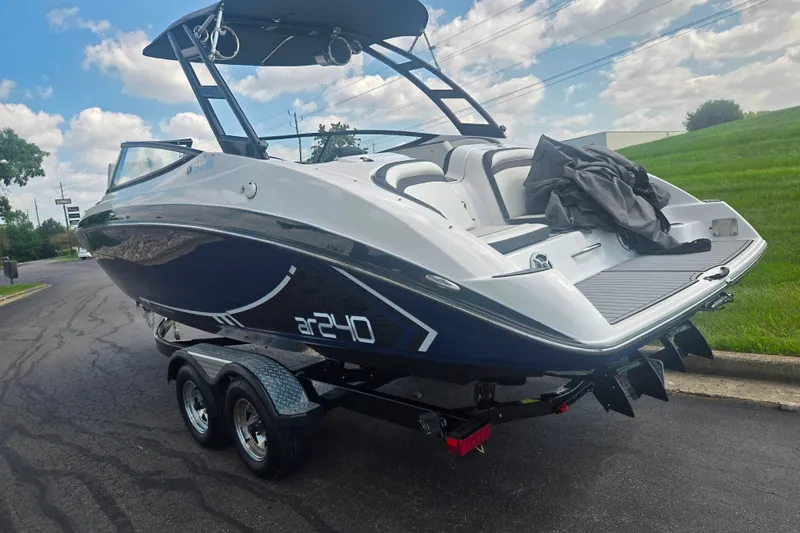 Slide: The Image of 2016 Yamaha Boats AR240 on trailer, sleek design, parked on paved road under blue sky. - 3