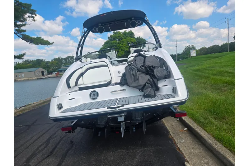 Slide: The Image of 2016 Yamaha Boats AR240 on trailer by a lakeside, under a blue sky. - 2