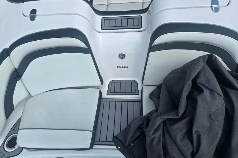 Slide: The Image of 2016 Yamaha AR240 boat interior with cushioned seating and a black jacket. - 10