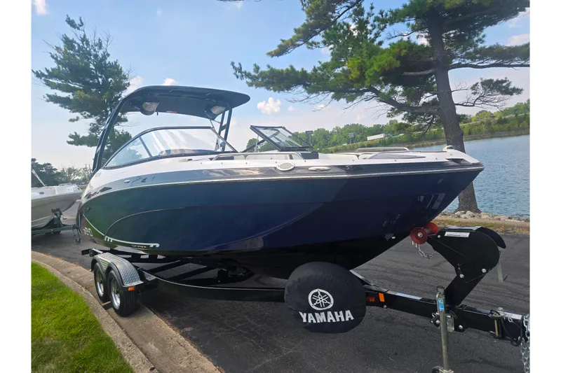 Slide: The Image of 2016 Yamaha Boats AR240 on trailer by lakeside, under clear blue sky. - 8