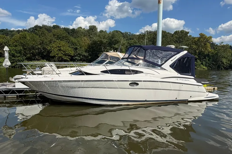 The Image of 2006 Regal 3360 Window Express boat docked on a calm lake under a clear sky. - 0