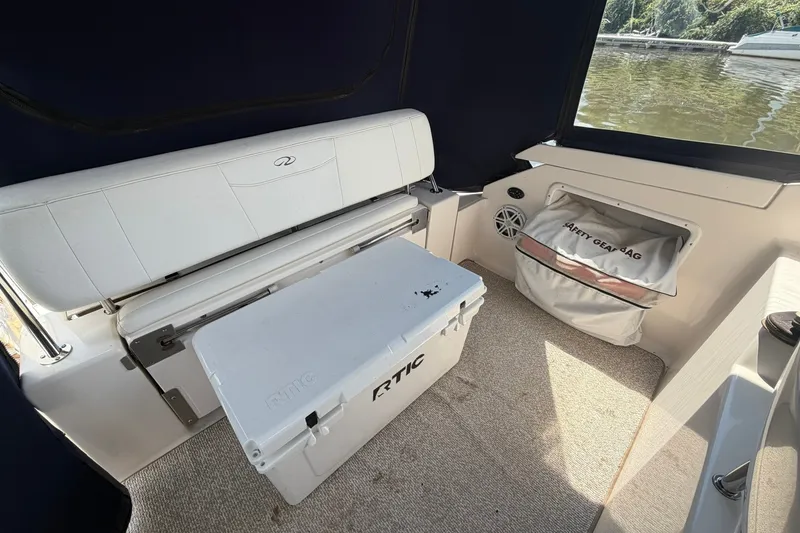Slide: The Image of 2006 Regal 3360 Window Express boat interior with seating, cooler, and safety gear bag. - 13