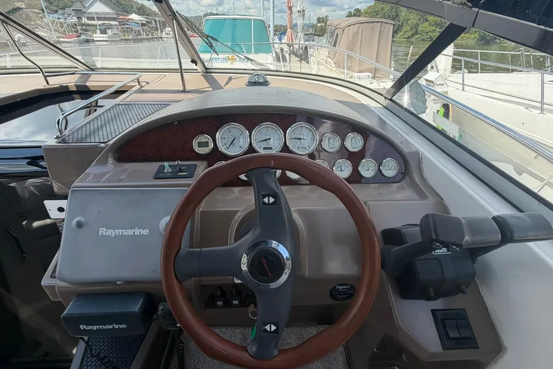Slide: The Image of 2006 Regal 3360 Window Express boat dashboard with steering wheel and gauges. - 16