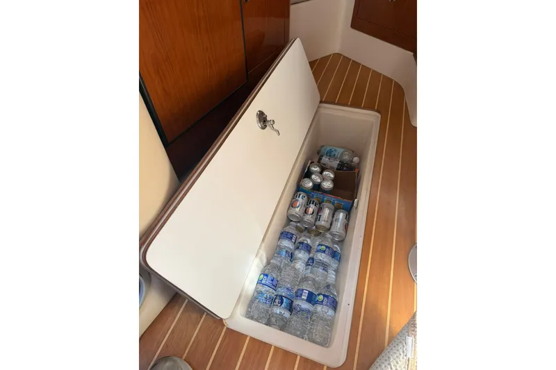 Slide: The Image of Storage compartment on 2006 Regal 3360 Window Express boat, holding bottled water and canned drinks. - 32