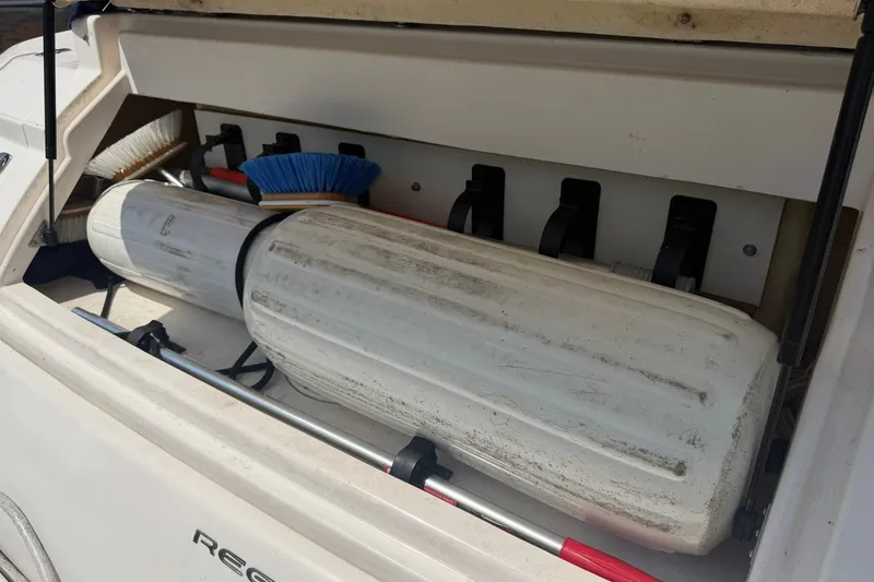 Slide: The Image of Storage compartment of a 2006 Regal 3360 Window Express boat with cleaning supplies. - 37