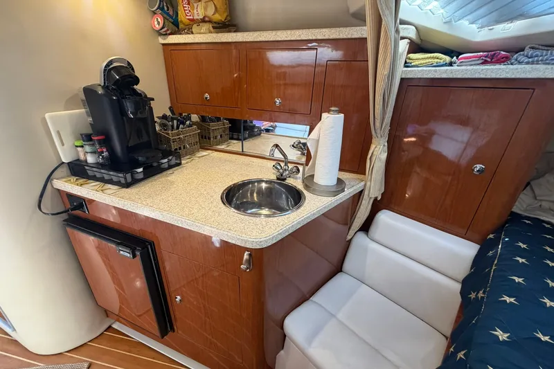 Slide: The Image of Compact galley in 2006 Regal 3360 Window Express with sink, coffee maker, and storage cabinets. - 29