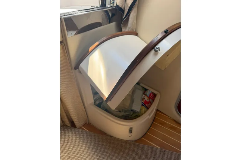 Slide: The Image of 2006 Regal 3360 Window Express interior storage compartment with open lid. - 33