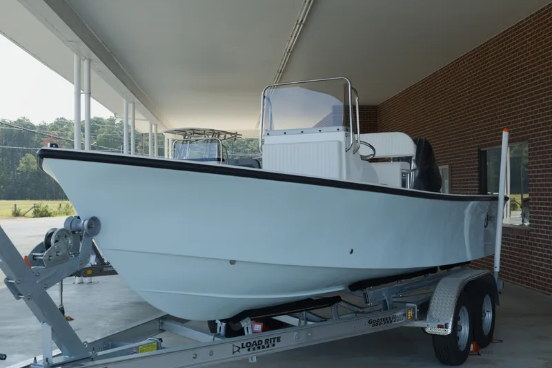 Slide: The Image of 2026 C-Hawk 20 Center Console boat on trailer, parked under a canopy. - 2
