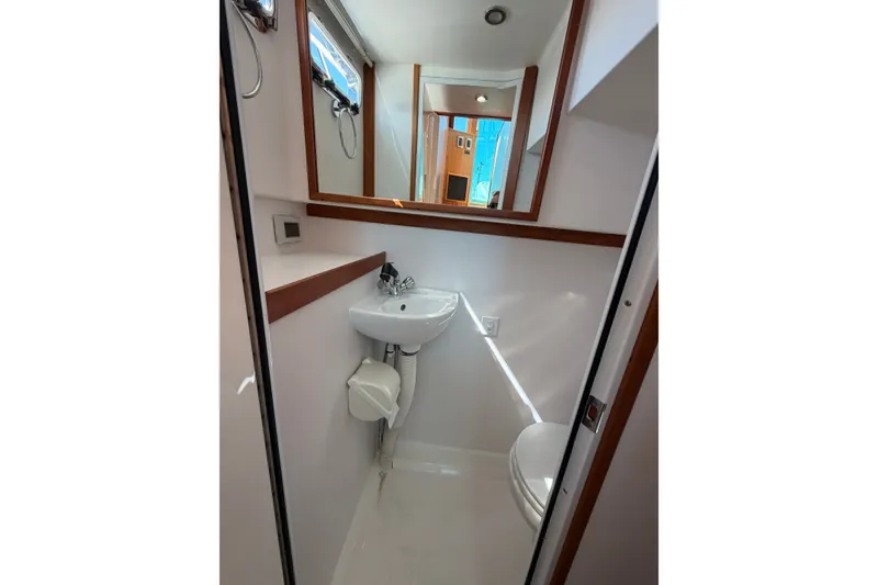Slide: The Image of Compact bathroom in 2018 Sabre 48 Salon Express yacht with sink, mirror, and window. - 25