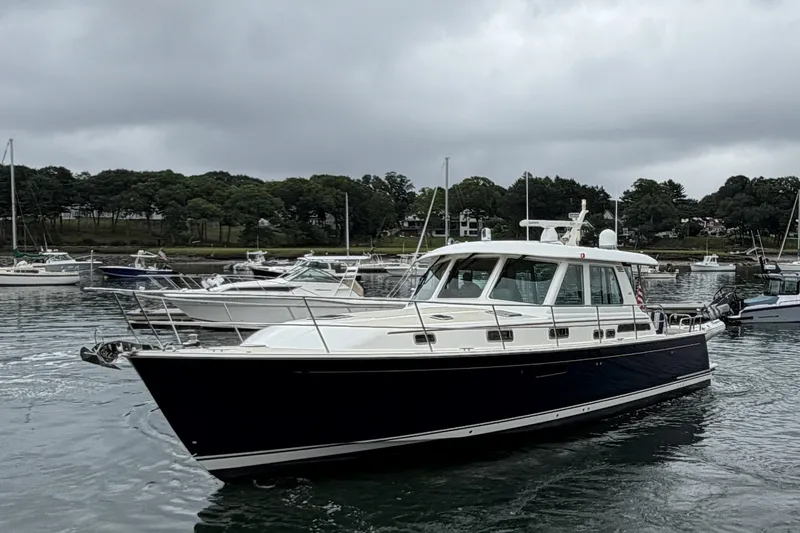 The Image of 2018 Sabre 48 Salon Express yacht on a calm harbor with overcast skies. - 0