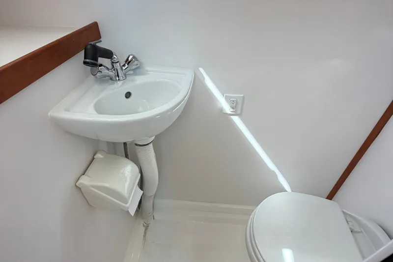 Slide: The Image of Compact bathroom in 2018 Sabre 48 Salon Express yacht with sink and toilet. - 26