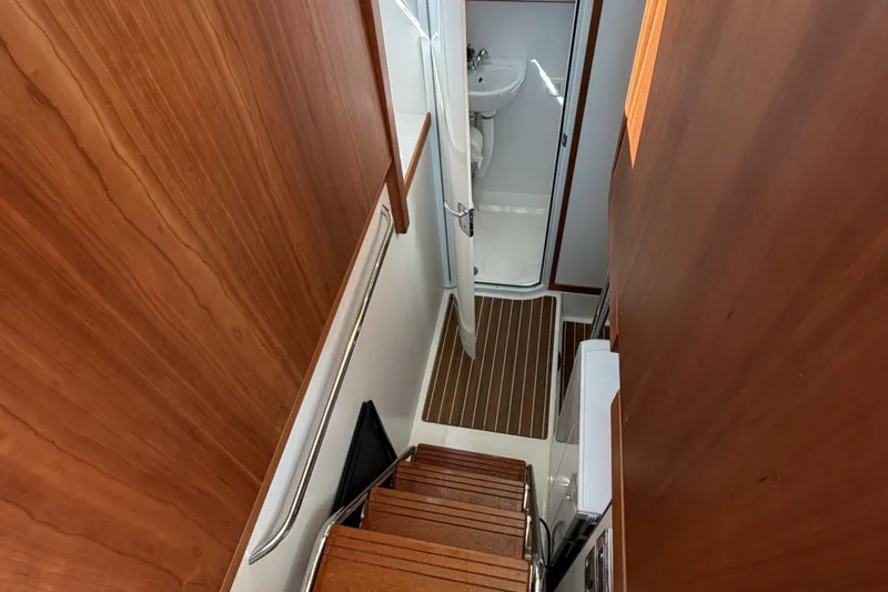 Slide: The Image of Interior view of 2018 Sabre 48 Salon Express yacht, featuring wooden stairs and compact bathroom. - 21