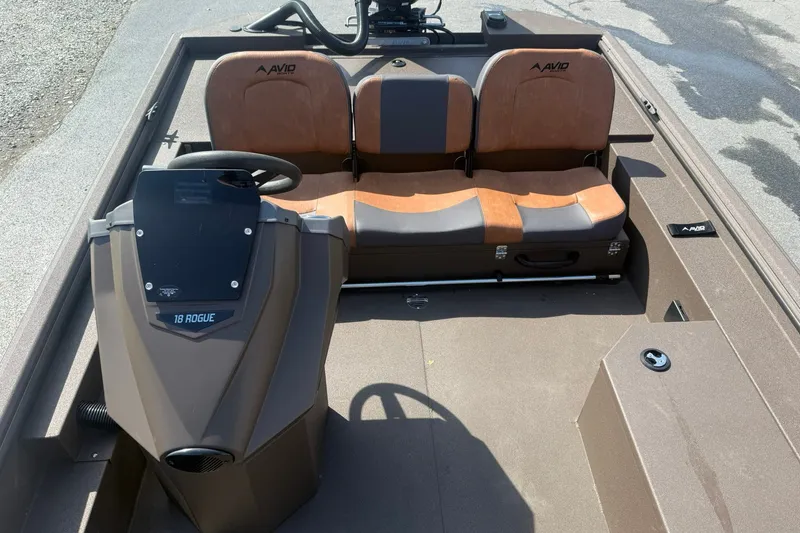 Slide: The Image of 2027 Avid 18 Rogue SC boat interior with dual brown seats and steering console. - 15