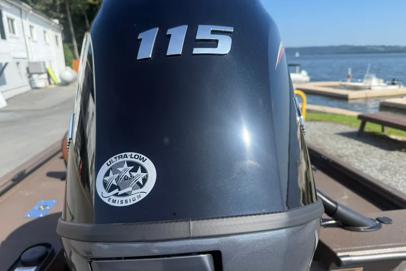 Slide: The Image of Outboard motor with "115" label and ultra-low emission sticker, near a waterfront. - 7