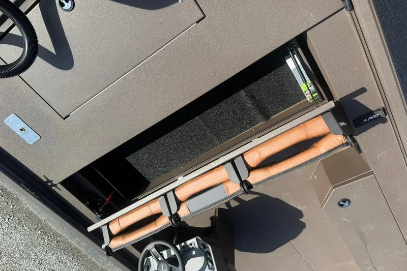 Slide: The Image of Interior view of 2027 Avid 18 Rogue SC boat storage compartment with rod holders. - 16