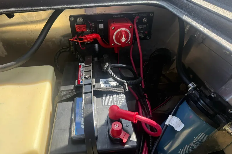 Slide: The Image of Battery compartment of 2027 Avid 18 Rogue SC with wiring and switch panel. - 18