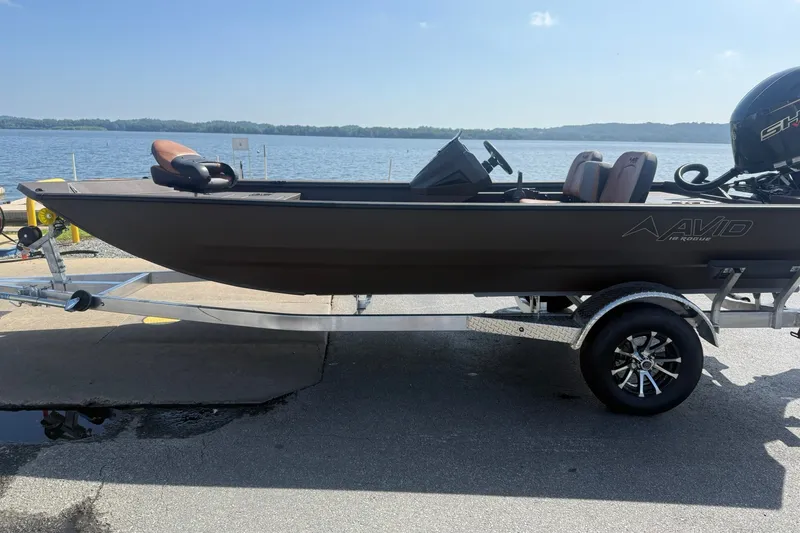Slide: The Image of Avid 18 Rogue SC 2027 boat on trailer by a lake, sunny day. - 9