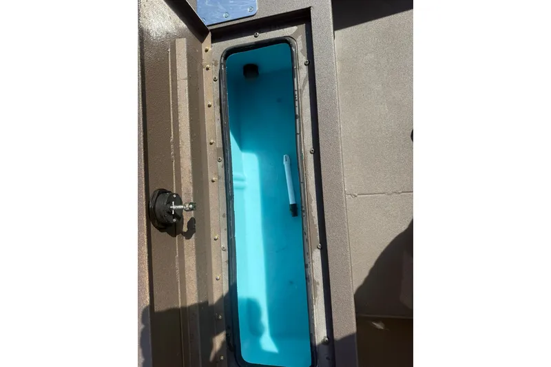Slide: The Image of Open storage compartment in 2027 Avid 18 Rogue SC boat, featuring a blue interior. - 13