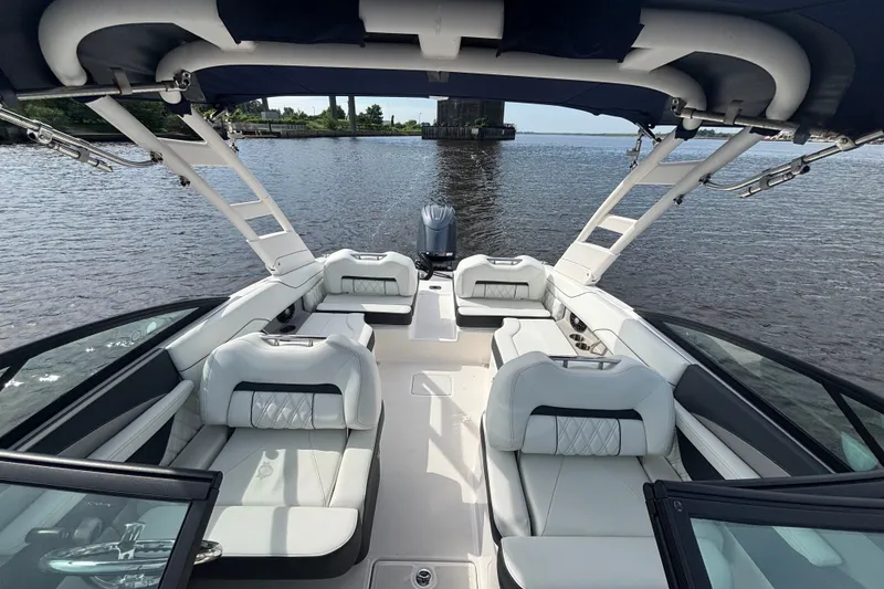 Slide: The Image of 2024 Regal LX2 boat interior with luxurious seating on a calm waterway. - 13