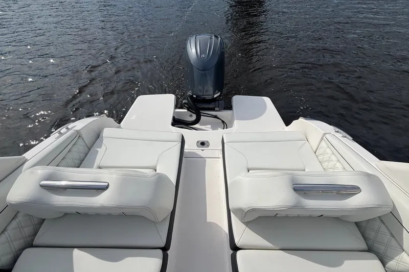 Slide: The Image of 2024 Regal LX2 boat with luxurious white seating and outboard motor on water. - 14
