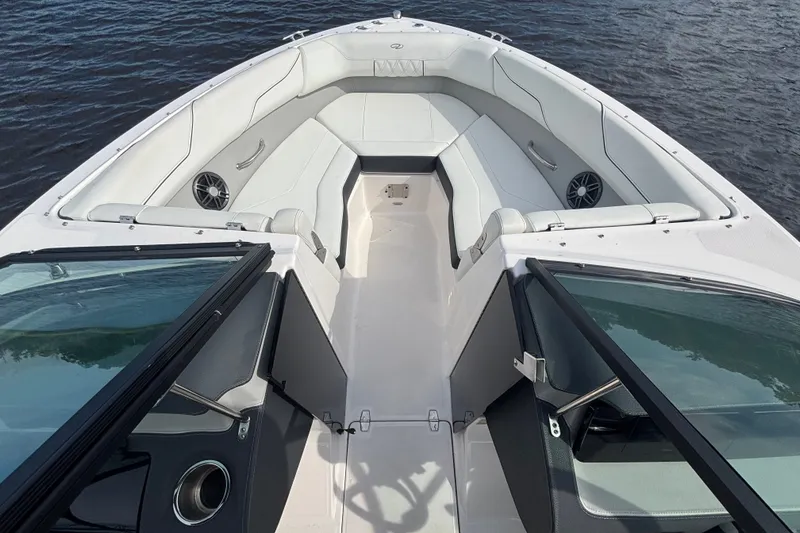 Slide: The Image of 2024 Regal LX2 boat interior with white seating and open windshield on water. - 12