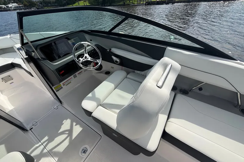 Slide: The Image of 2024 Regal LX2 boat interior with sleek dashboard and comfortable seating by the water. - 16