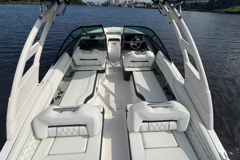 Slide: The Image of 2024 Regal LX2 boat interior with luxurious seating on a calm lake. - 15